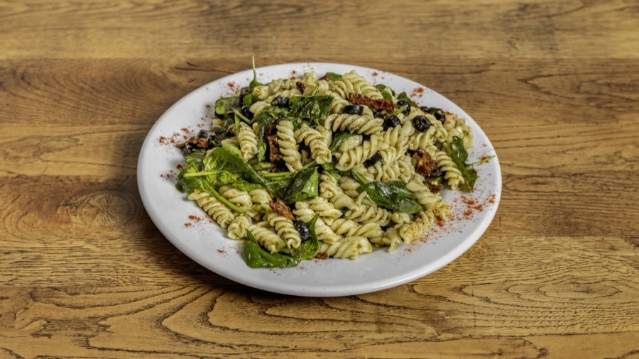Pesto pasta salad with spinach and sun-dried tomatoes.
