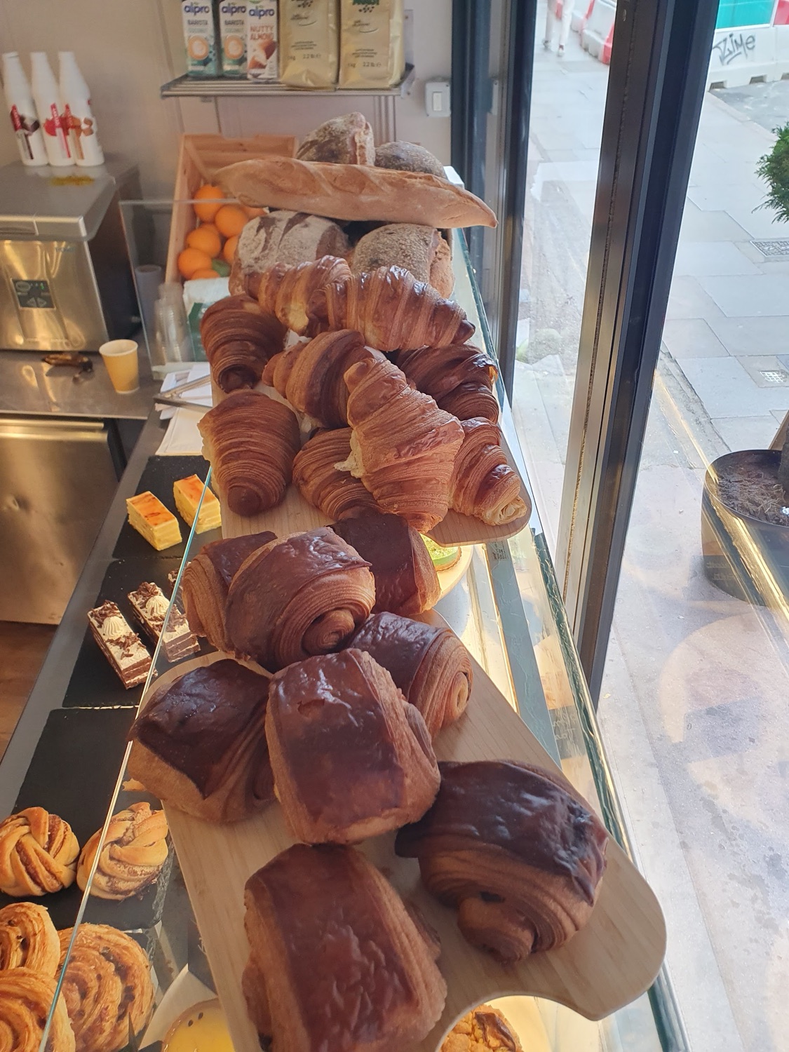 Fresh croissants, pain au chocolat and cinnamon rolls on the counter in the window at The Barrel Boulangerie.