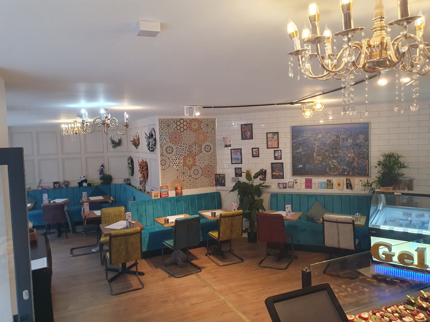 The dining room at The Barrel Boulangerie with teal velvet banquettes and gold chandeliers.